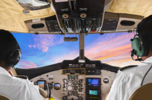Pilots in the plane cockpit and sunset - transportation background